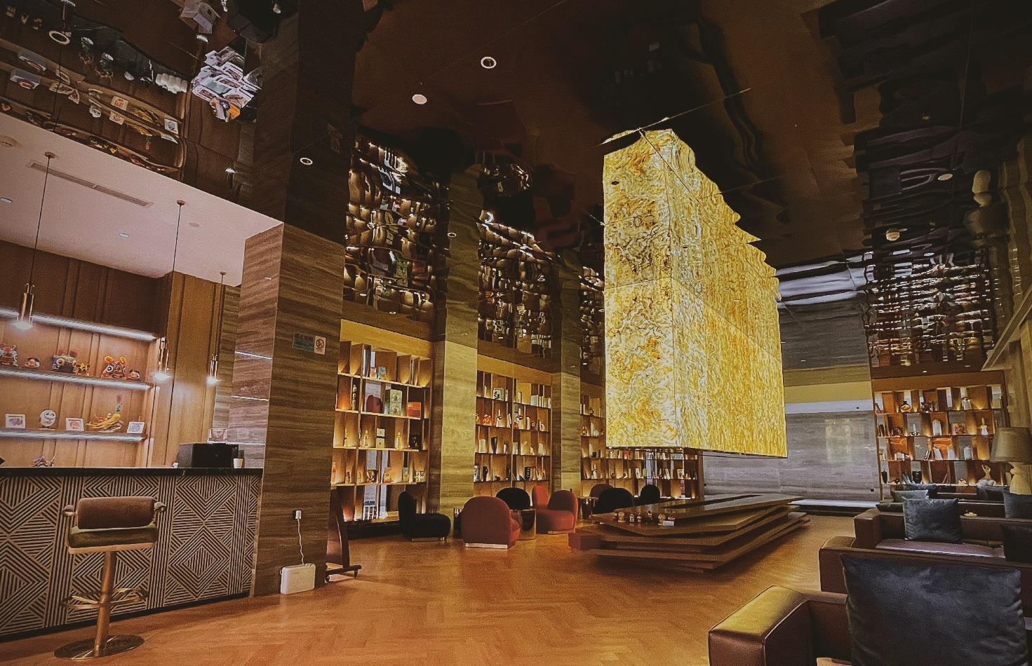 Light-transmitting stone suspended as a luminous architectural centerpiece in a hotel lobby